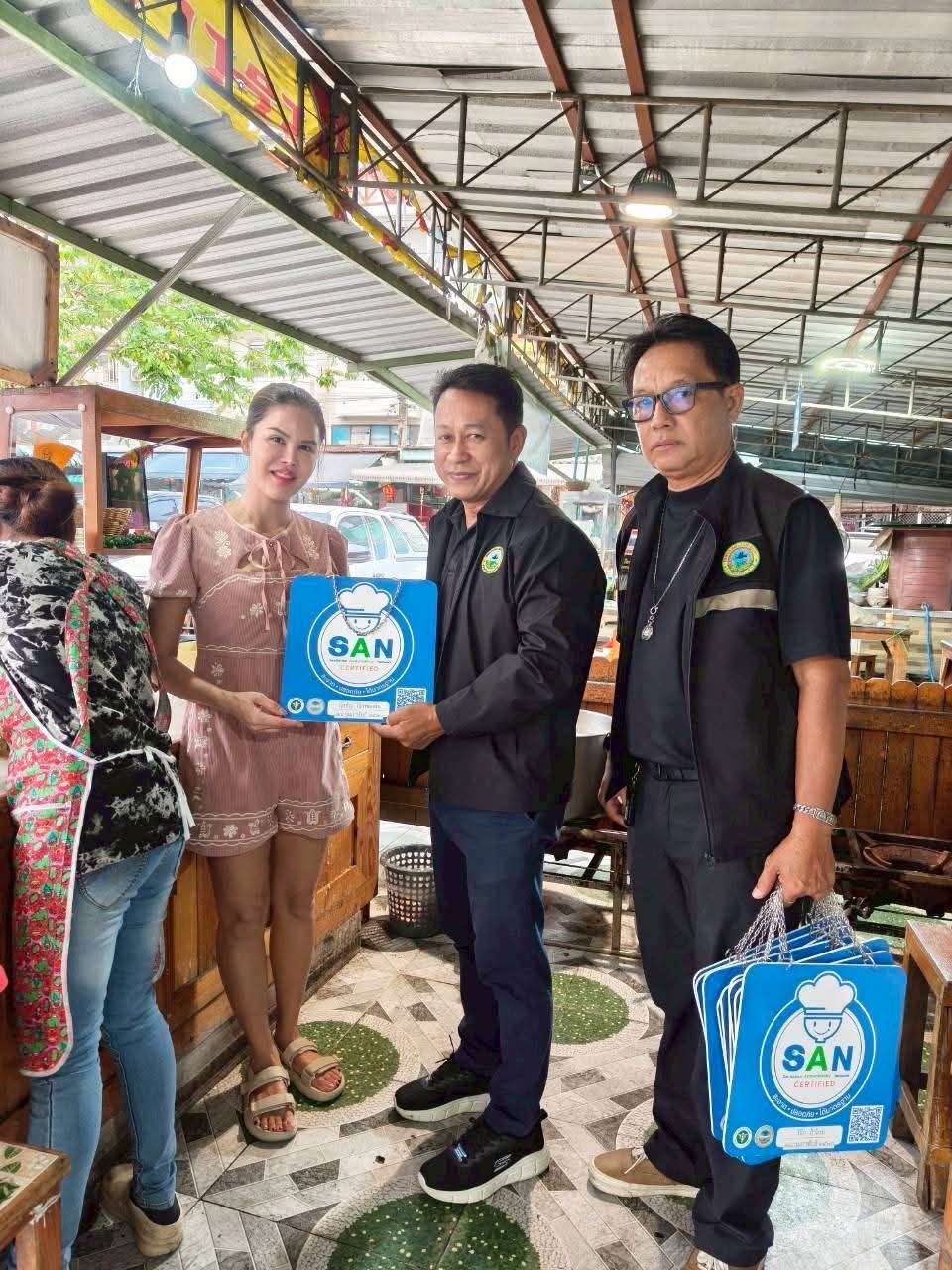 นายกแสน กิตติเดช ลานทอง นายก ทต.ลำลูกกา มอบป้าย SAN (สะอาด ปลอดภัย ได้มาตรฐาน) เพื่อส่งเสริมสุขอนามัยและความปลอดภัยด้านอาหารแก่ผู้ประกอบการภายในตลาด